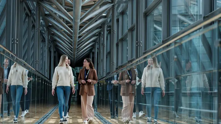 Tietoevry employees with badges meeting and walking in the office