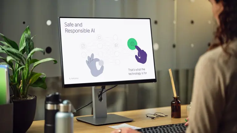 A lady working in the office with a computer creating an Ai-related presentation slide
