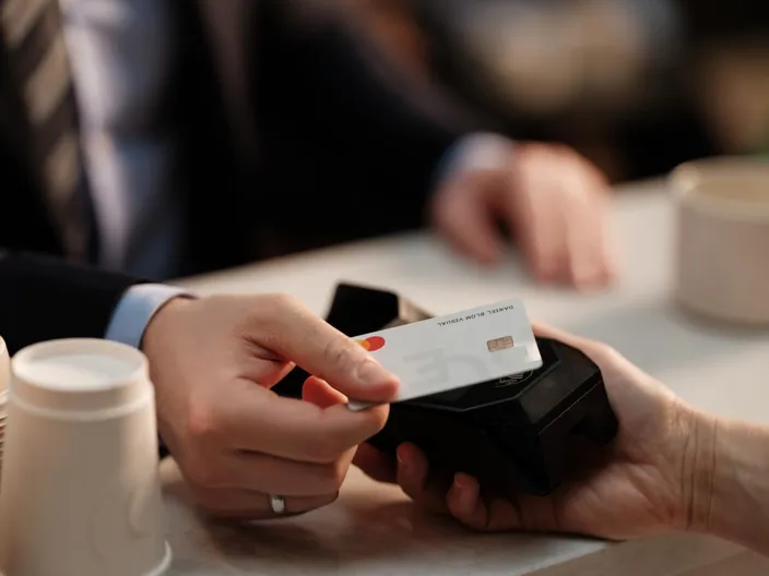 A closeup of a man's hand using a card payment with a terminal