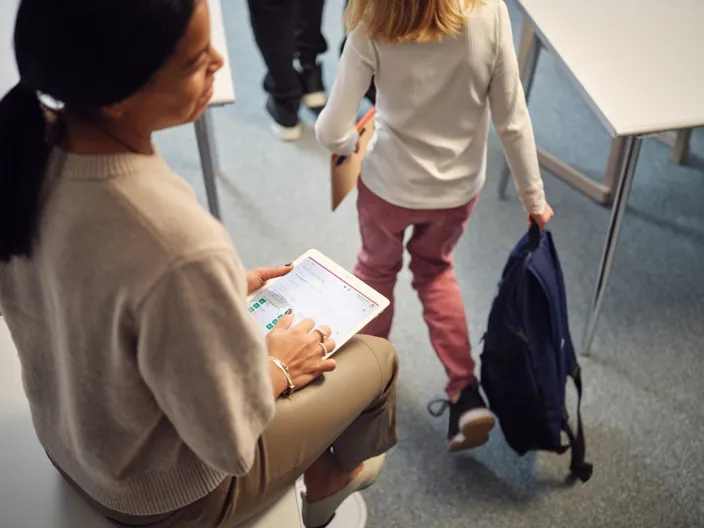 A teacher checking attendance in a school class 