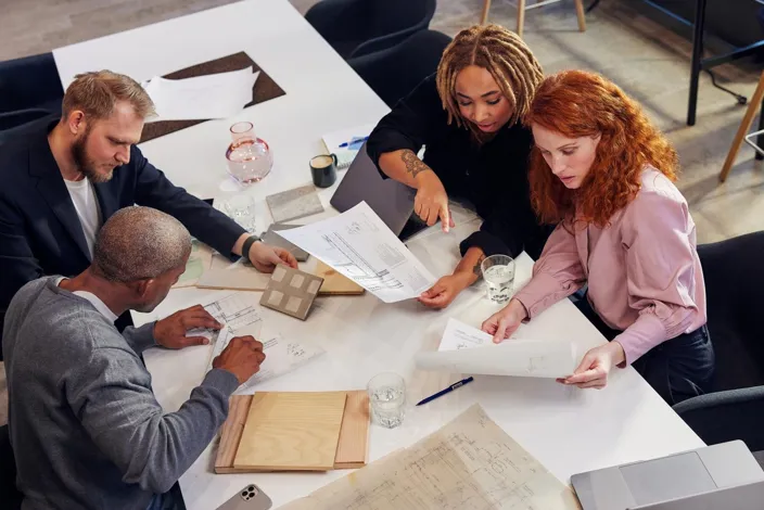 People working together on blueprints over a large table