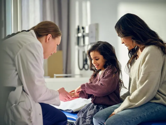 A doctor examining a child with her mother