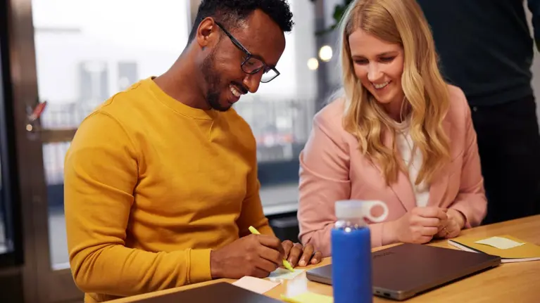 Man and woman in a collaboration meeting working together using sticky notes