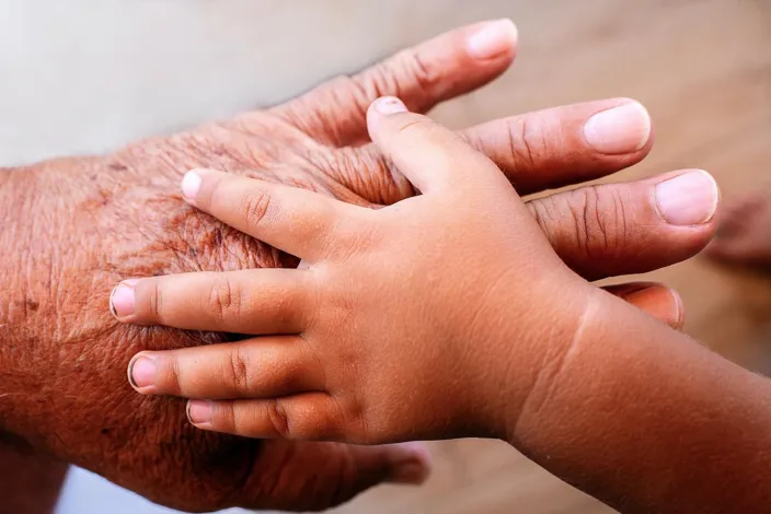 Hand of baby on mans hand