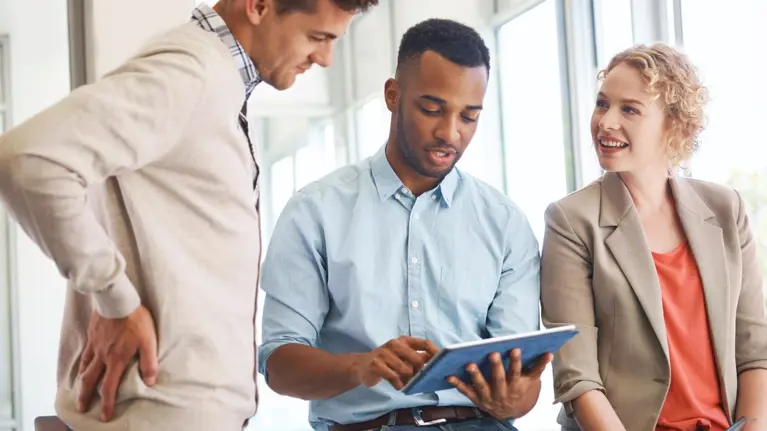colleagues talking, looking at the tablet