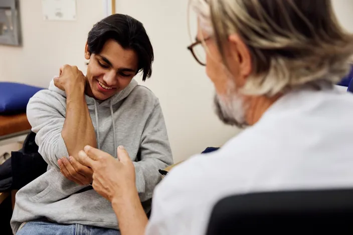 Doctor examining patient's arm during appointment