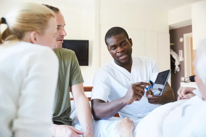 health professional showing patient and his family results of the test on the tablet screen