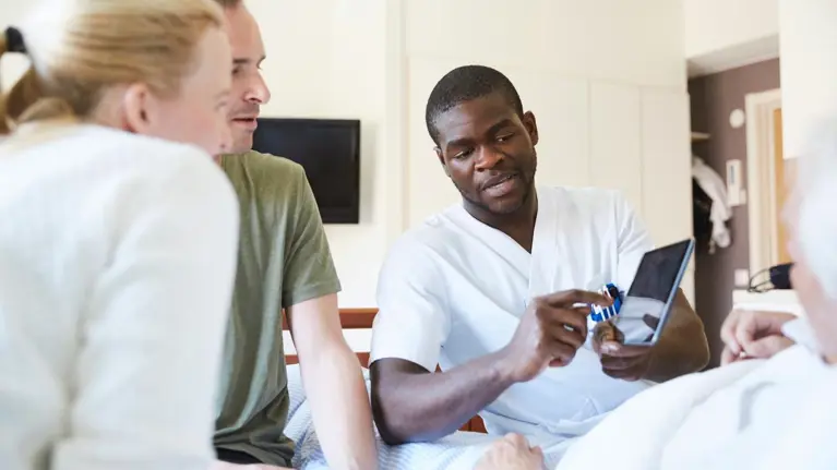 health professional showing patient and his family results of the test on the tablet screen