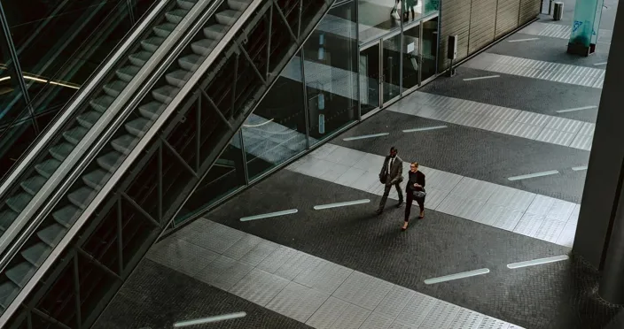 two people walking in financial district in urban environment modern architecture