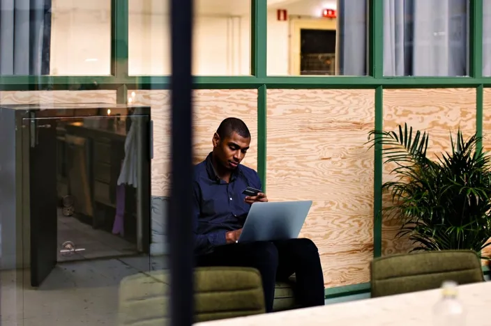 Young black man using bank card paying online using laptop