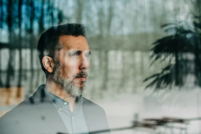 Close-up of thoughtful businessman seen through glass window at office