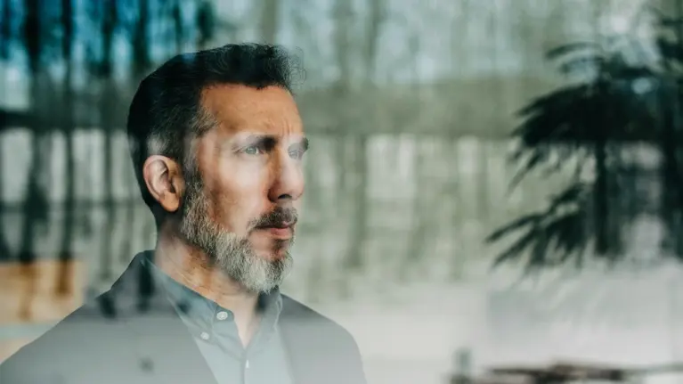 Close-up of thoughtful businessman seen through glass window at office