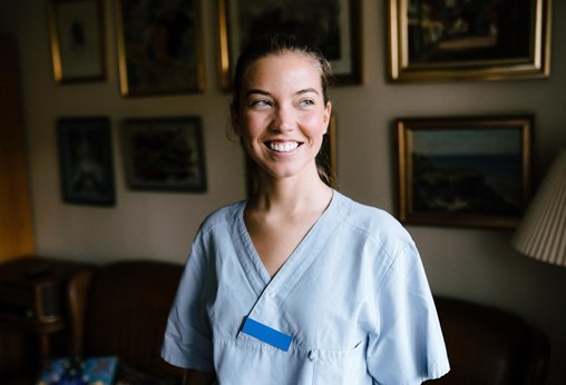 Happy female nurse looking away in living room