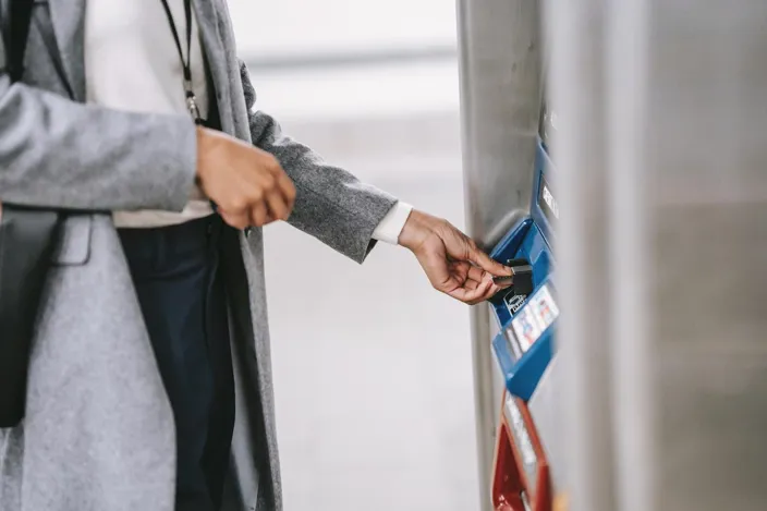 Woman holding a card and using an ATM