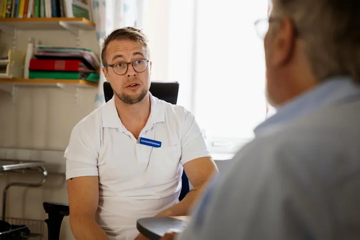 Male heart surgeon giving advice to senior man in clinic