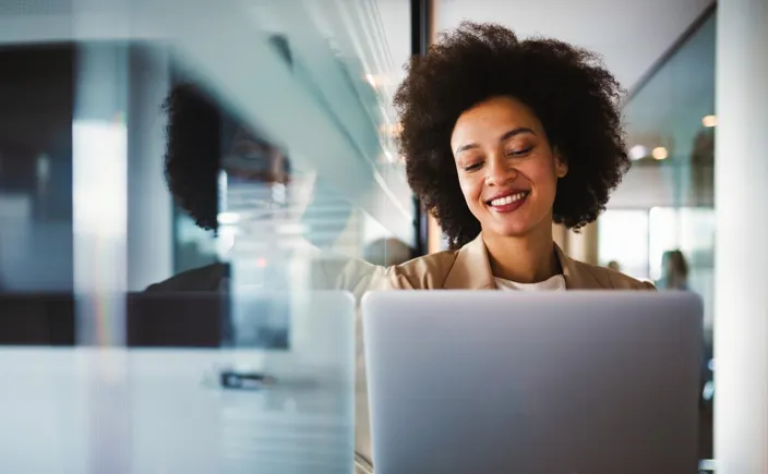 Young woman in online meeting on laptop smiling