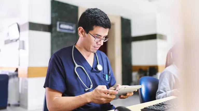 Young medical doctor is using an ipad tablet doing administration and medical healthcare reports
