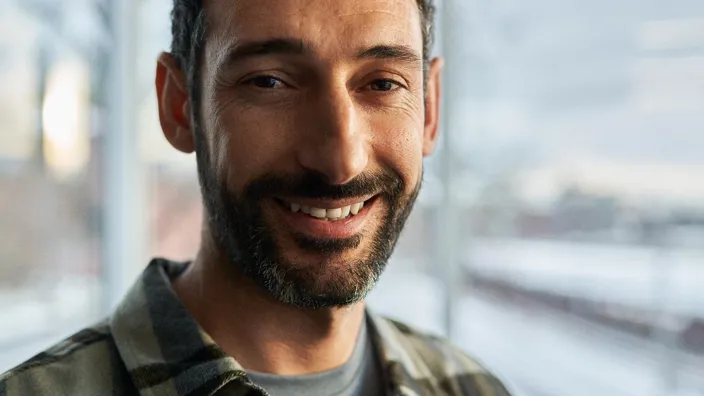 Close-up portrait of a young man                                smiling looking into the camera