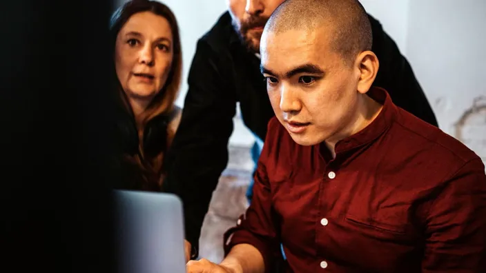 coworkers working on laptop in the office