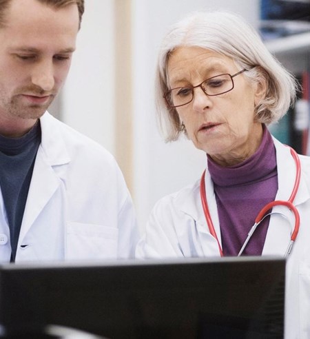 two medical professions looking at a computer screen