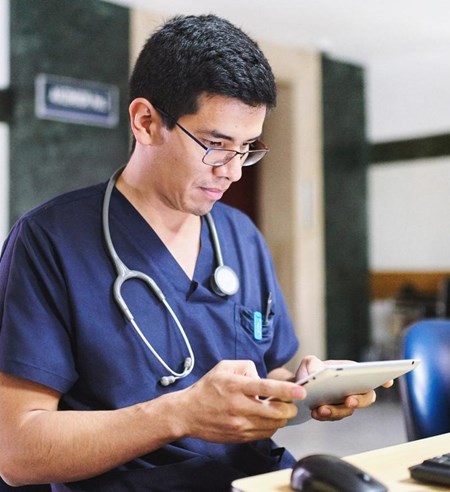 Young medical doctor is using an ipad tablet doing administration and medical healthcare reports