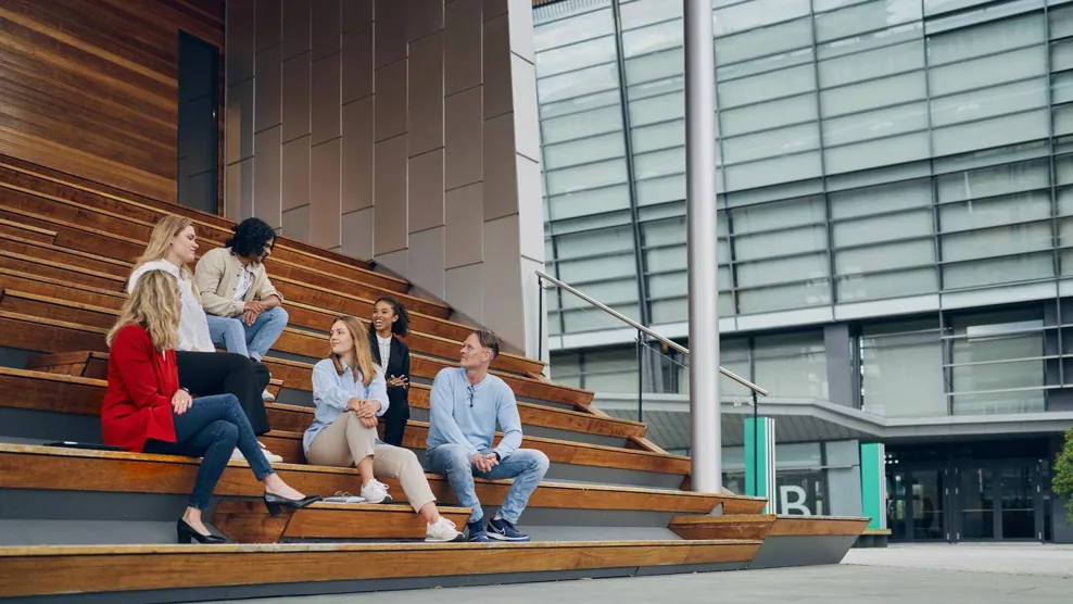 Tietoevry employees meet next to the office building smiling