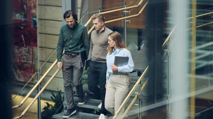 Three employees walking down the stairs in Tietoevry office