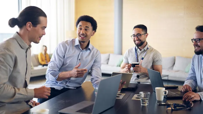 several people in office in meeting smiling