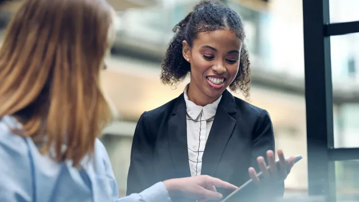 Two young women work with tablet in Tietoevry office