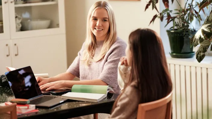 Two girls studying at table in livingroom