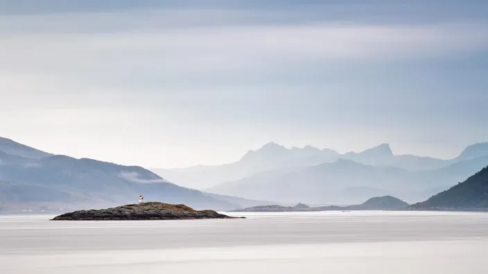 Coast of  Norway sea in clouds of haze. Beacon on a rock. Cloudy Nordic day on Lofoten islands