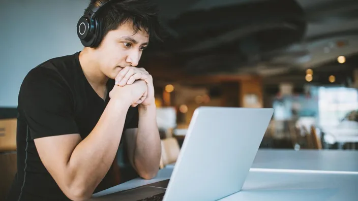 man looking at this laptop screen