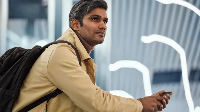 man in transit on subway with phone looking away