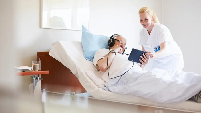 nurse looking at patients tablet