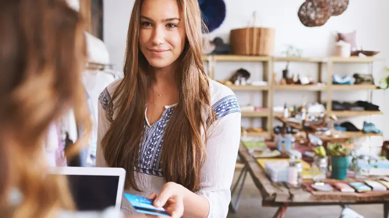 Teenage young woman paying with credit card in a boutique