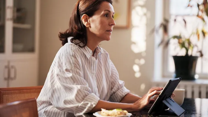 Woman using tablet at dinner table at home