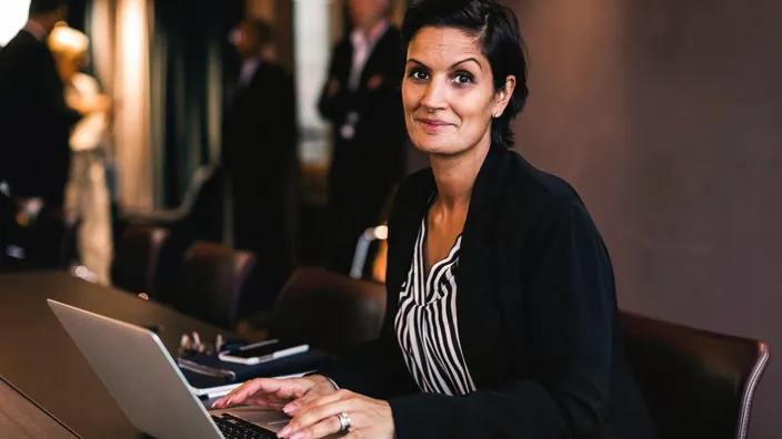 Portrait of smiling businesswoman with laptop at office