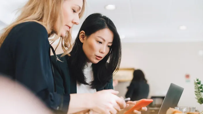 Colleagues use mobile phones during conferences in offices